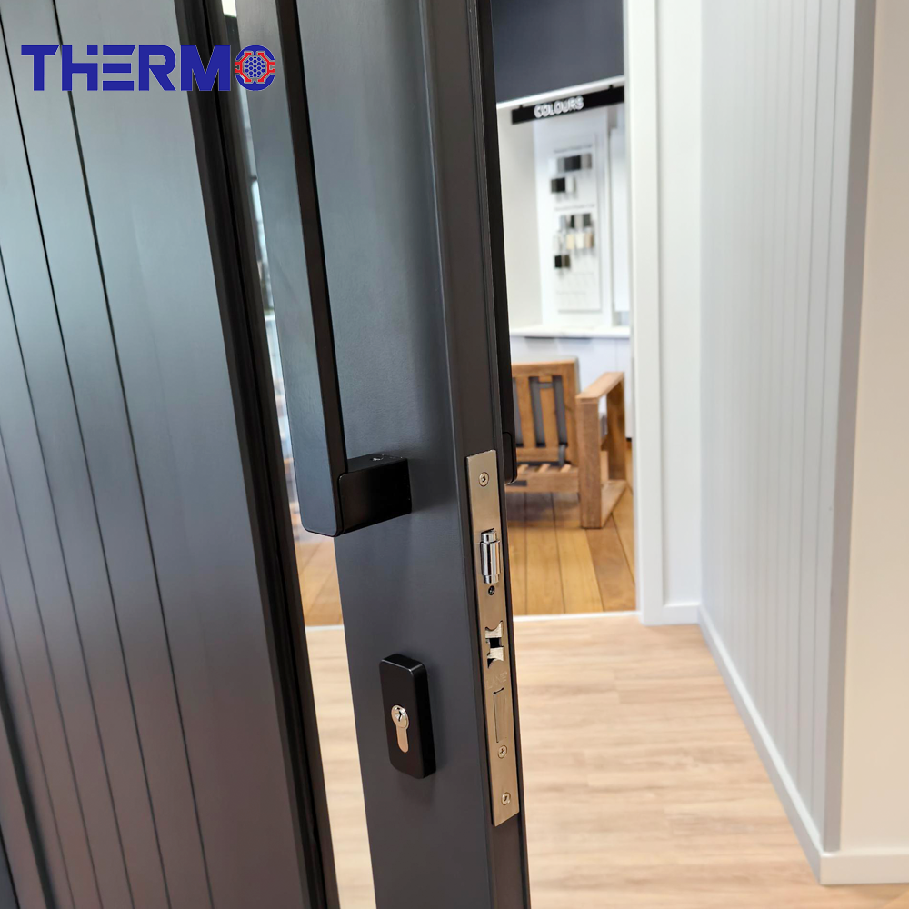 Puerta de entrada de aluminio Therm Modern con inserto vertical de vidrio exterior y acabado imitación madera.