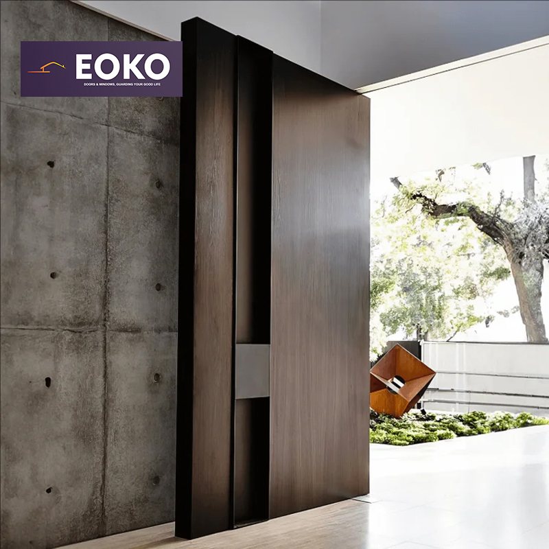 Puerta pivotante exterior de aluminio con acabado de vetas de madera personalizadas EOKO para entradas de casas en Estados Unidos.