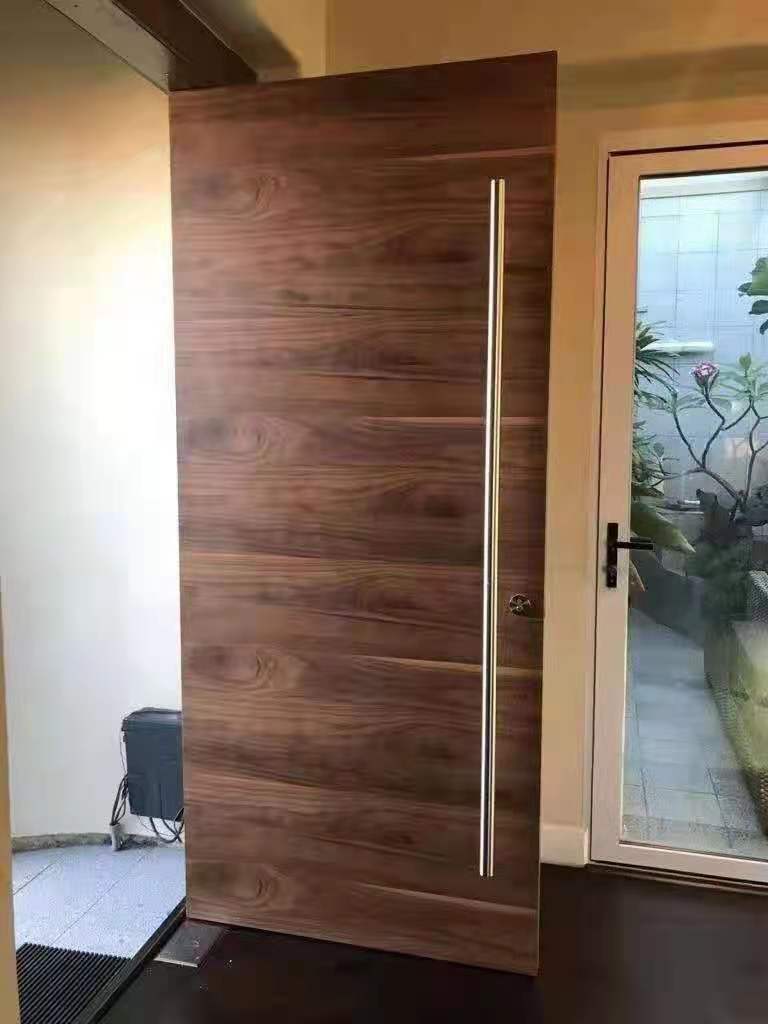 Instalación de herrajes en puerta pivotante de madera